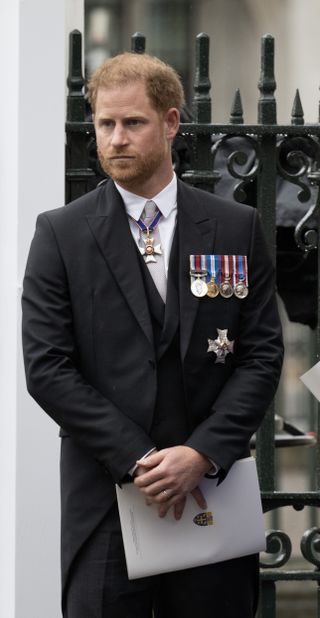 Prince Harry stands outside at the Coronation ceremony at Westminster Abbey