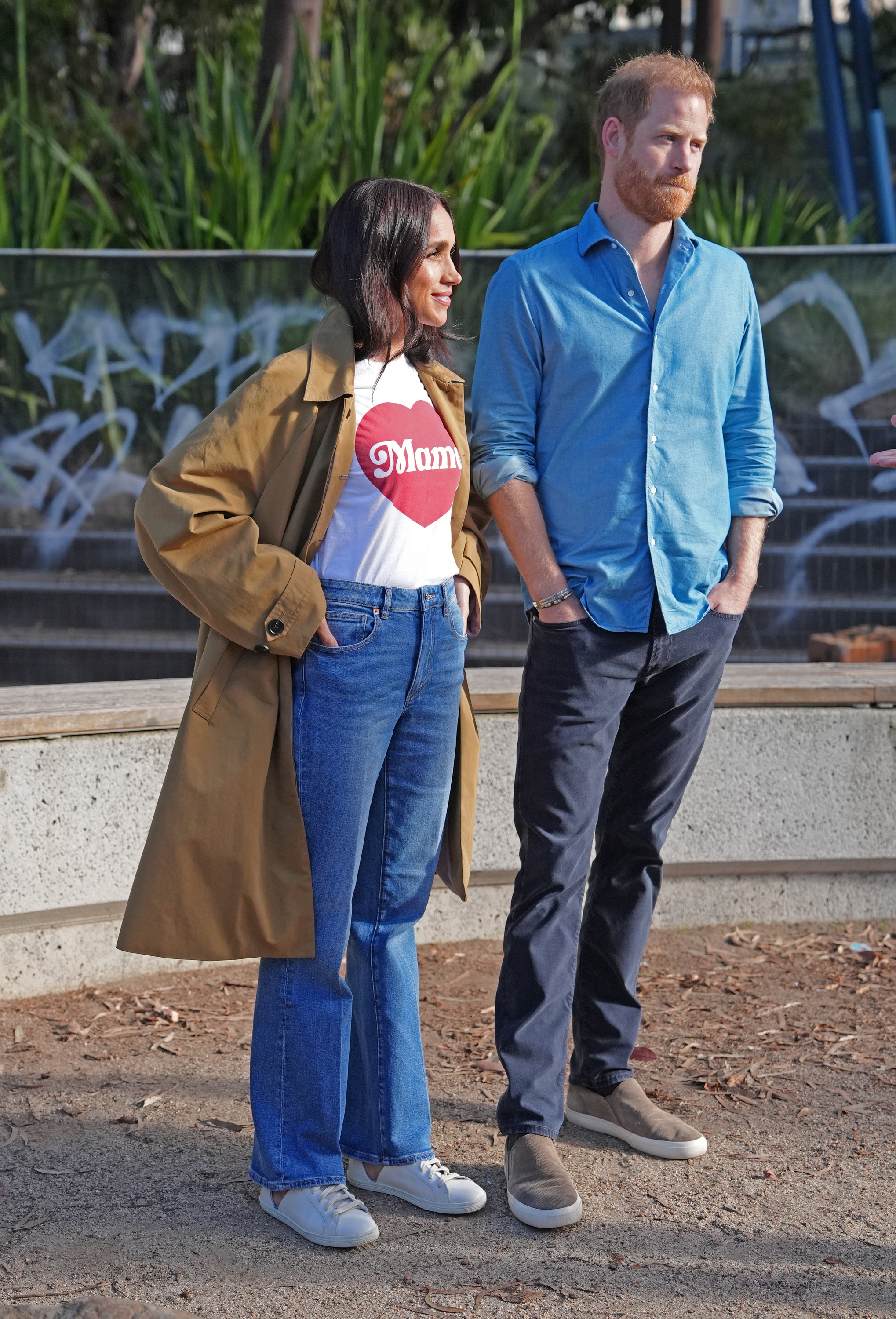 Meghan Markle wearing jeans and a T-shirt standing next to Prince Harry