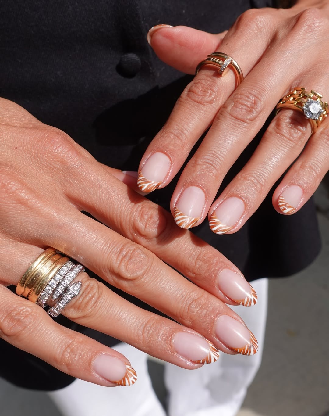 an animal print French manicure with orange and white stripes