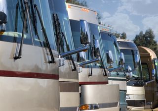 A row of new RVs at a dealership.