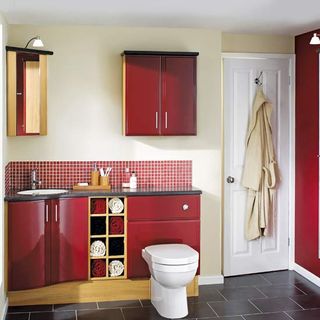 bathroom with red cabinets and dark flooring