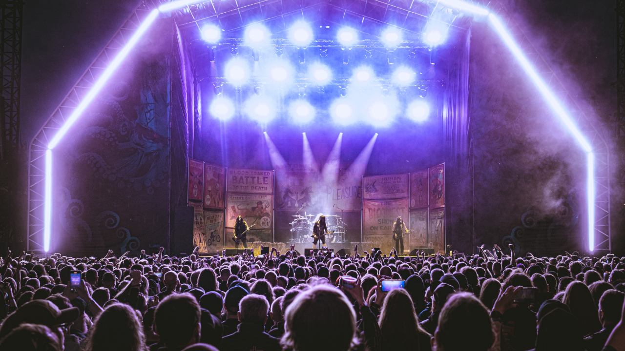 A crowd gathered in front of a festival stage at night
