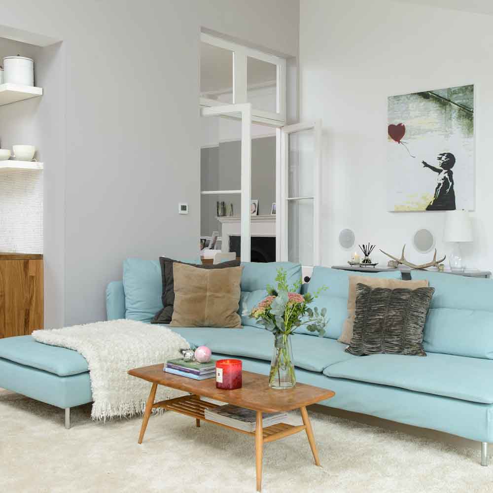 living room with green sofa and white wall