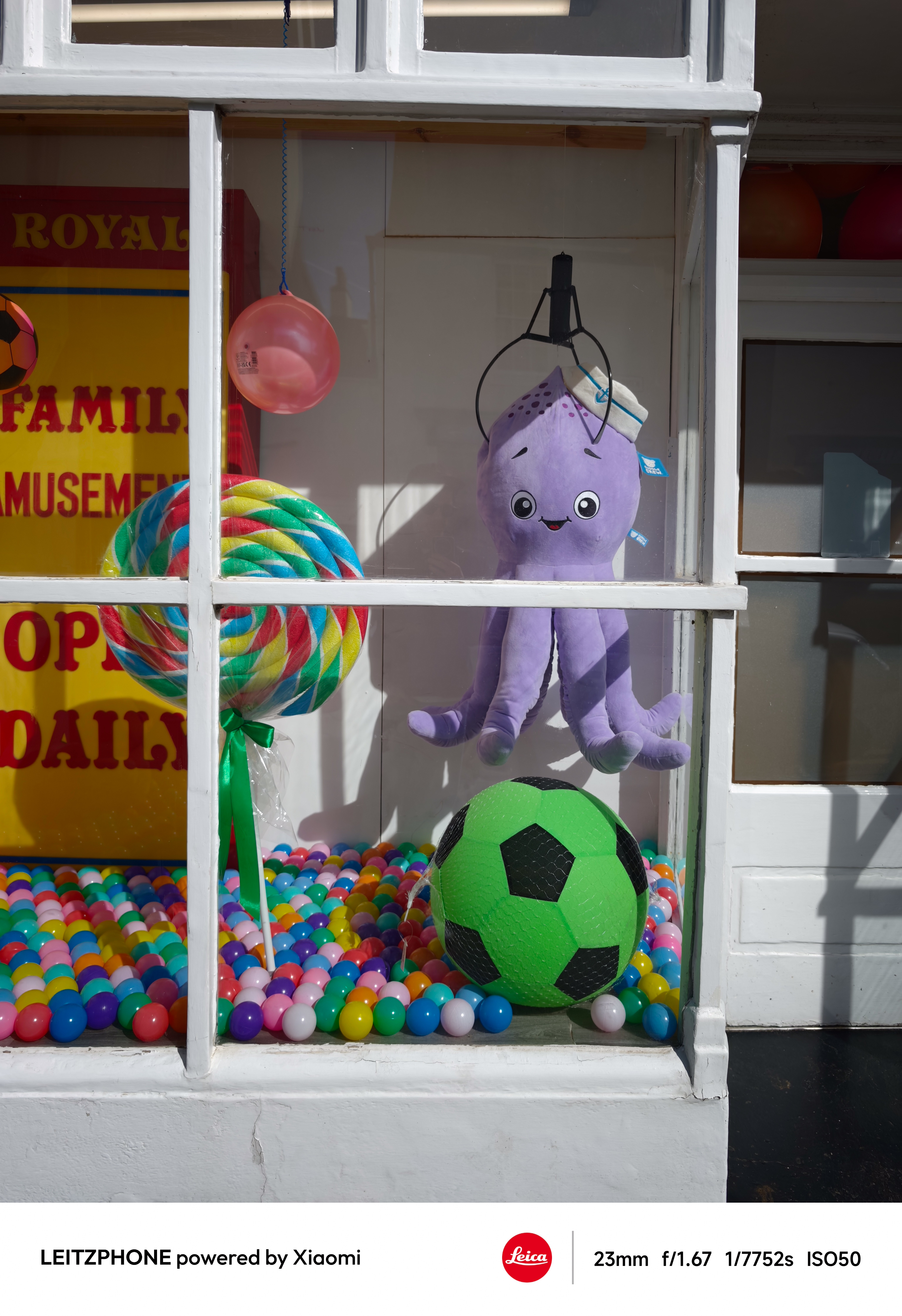 Storefront window with toy claw, plush octopus, and colorful balls