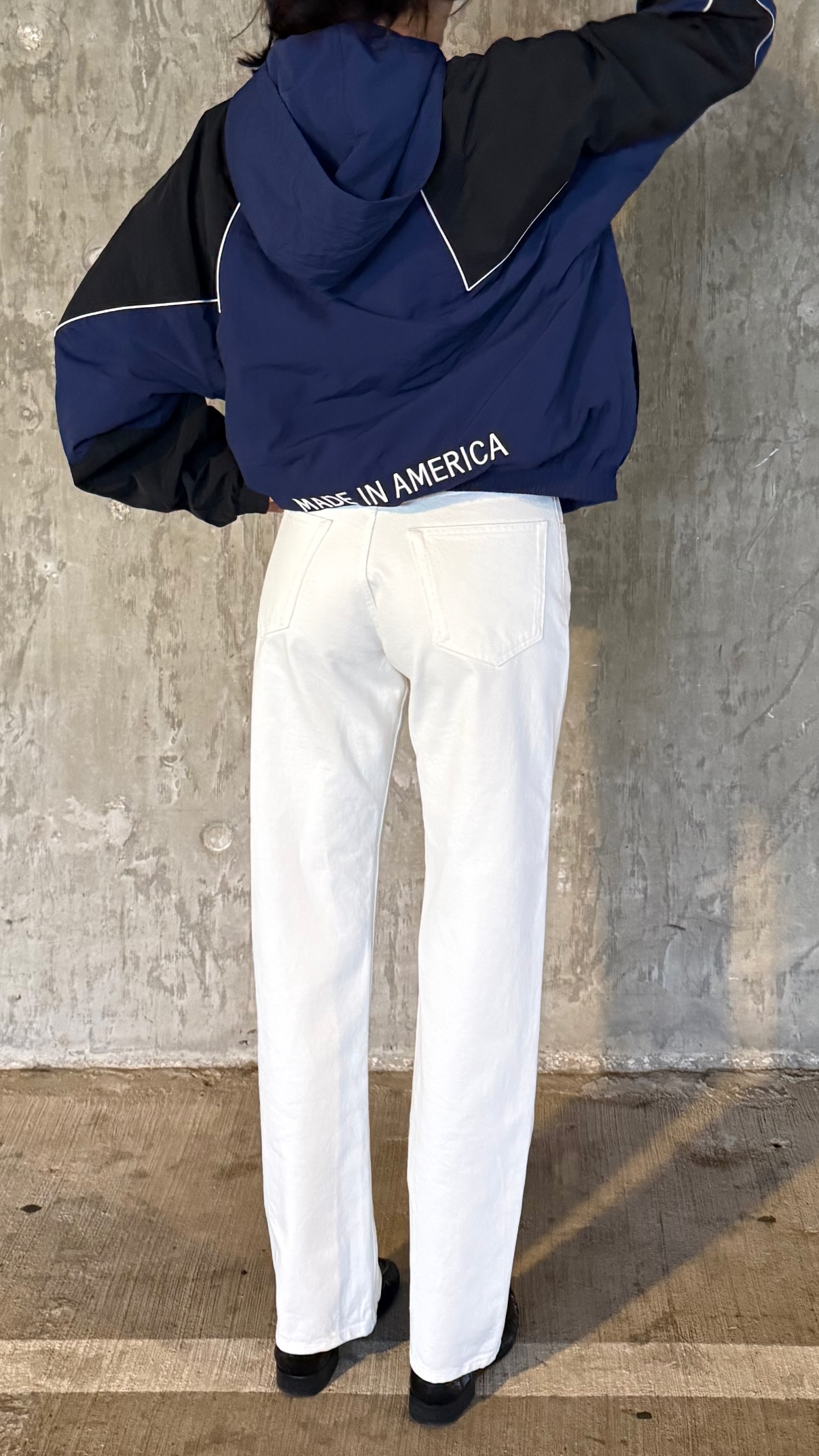 Kendall Jenner wears a track jacket, white pants, and black loafers