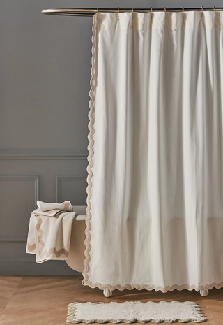 cream shower curtain over a freestanding bath