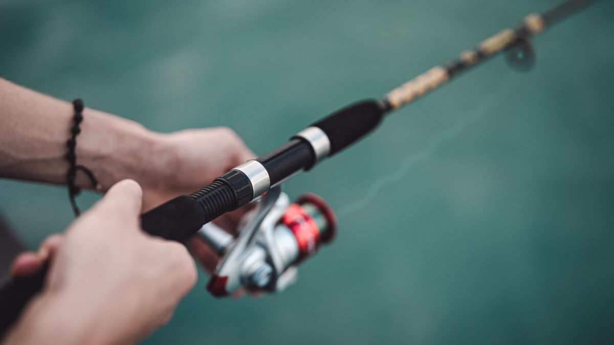 Close-up of man&#039;s hands holding fishing rod