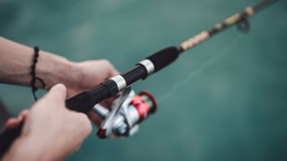 Close-up of man's hands holding fishing rod