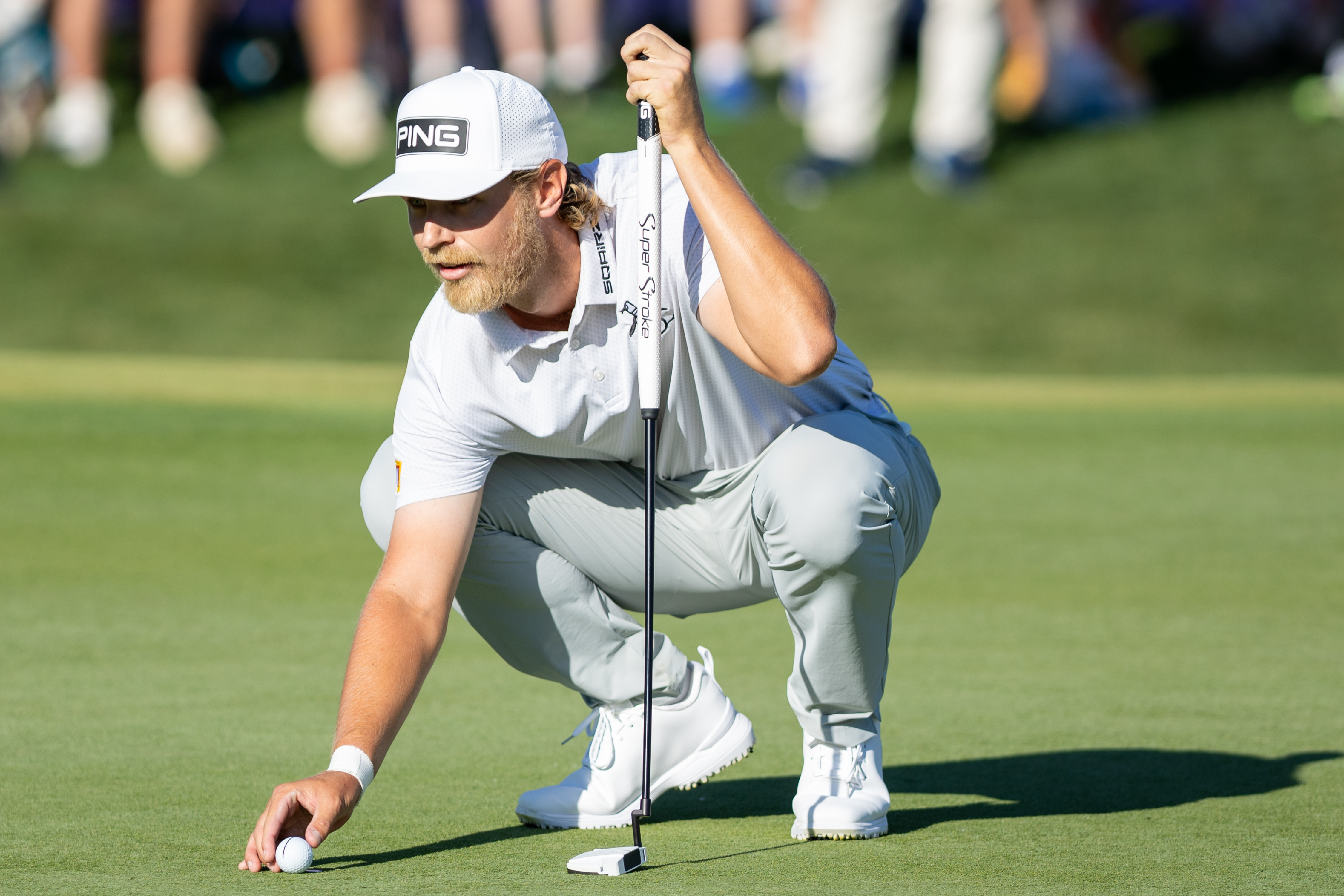 Kristoffer Reitan of Norway places his ball on the green of the 18th hole during the final round of the Truist Championship
