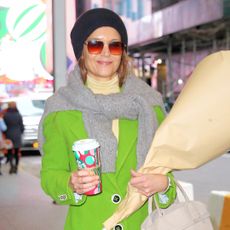 Katie Holmes wears a green coat with a banana republic turtleneck and banana republic jeans