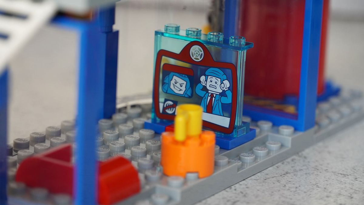 A small picture of a sinister-looking face and a man looking frightened is placed on some grey bricks.