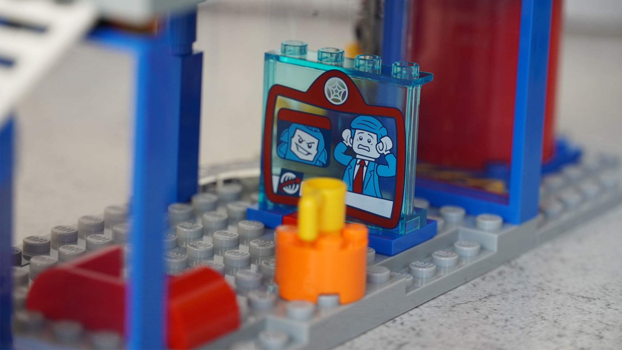 A small picture of a sinister-looking face and a man looking frightened is placed on some grey bricks.