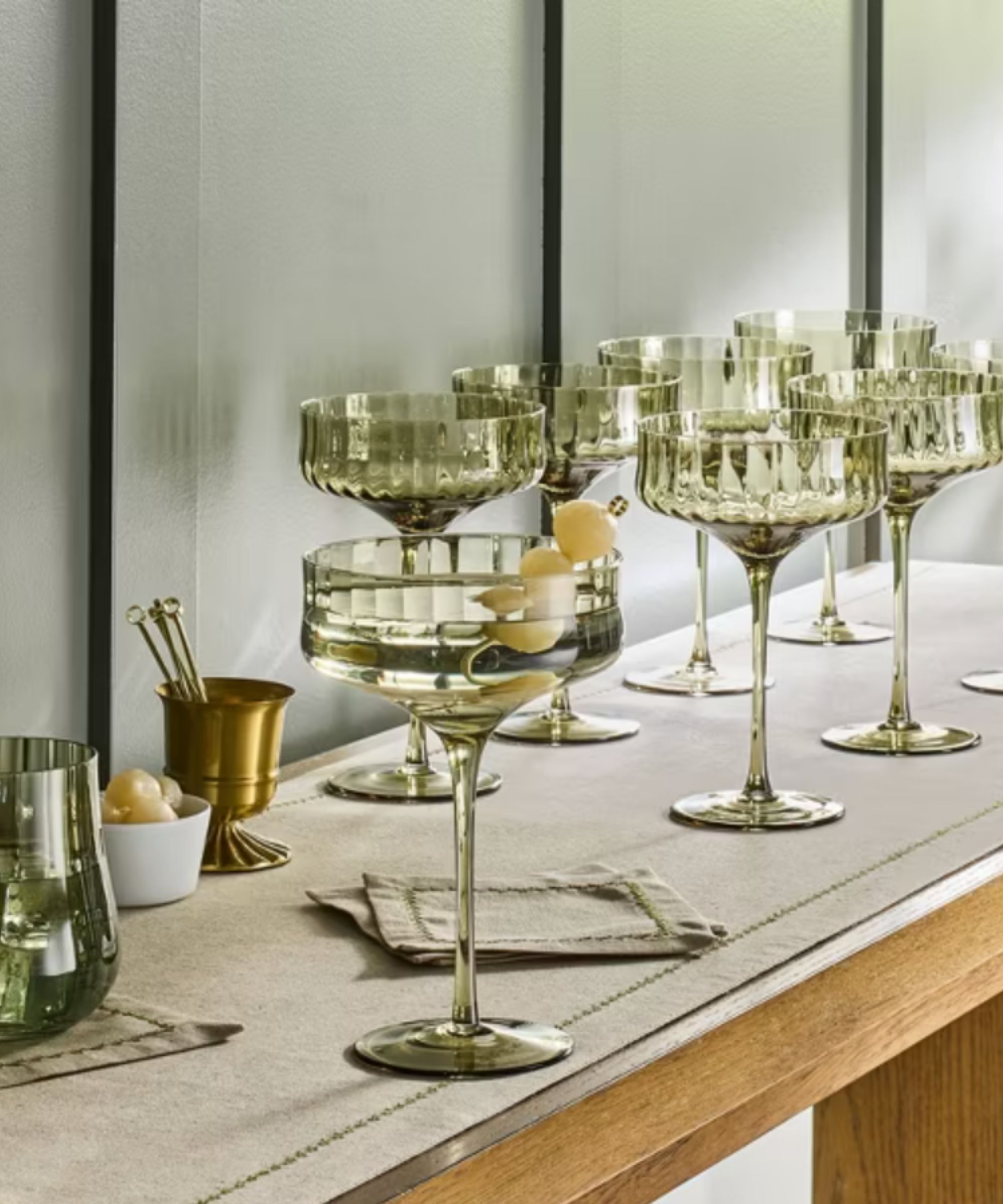 Green coupe glasses on a cocktail table