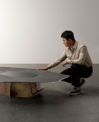 Portrait of Wonmin Park with a low table from the collection, made of raw stone and steel top