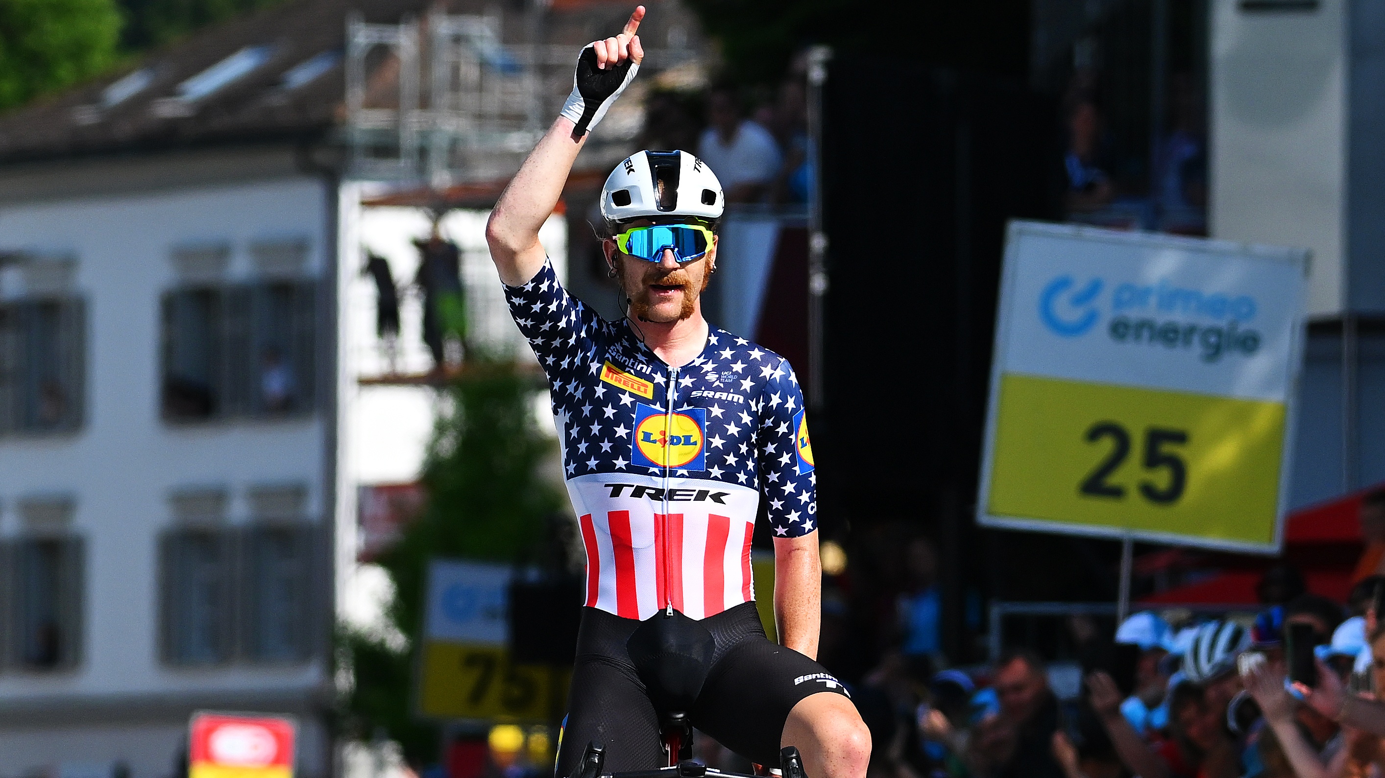 Quinn Simmons wins stage three of the Tour de Suisse and celebrates by lifting his finger in the air.