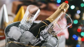 champagne in bucket of ice with glasses