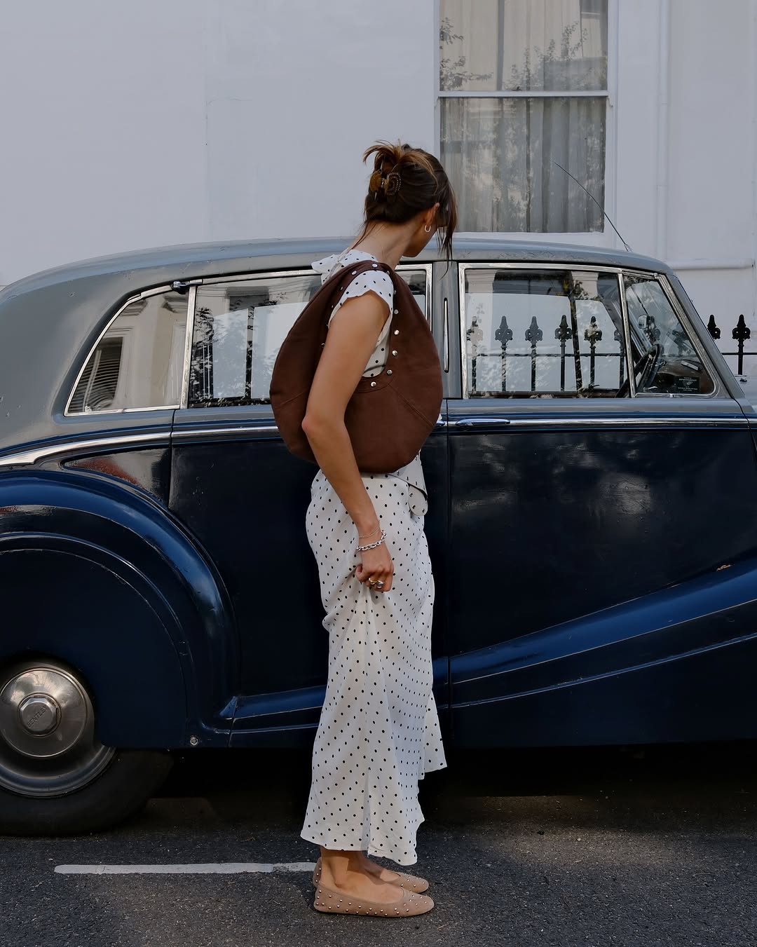 Woman wearing fall brown suede bag trend.