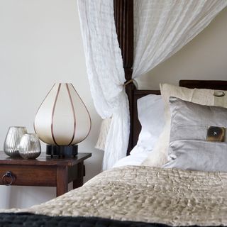 bed with neutral cover and bedside lamp