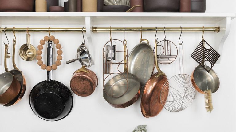 ways to organize pots and pans rustic copper pots and pans hanging on a gold rail in a white kitchen 