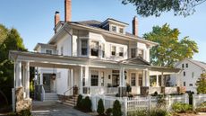 Queen anne home with white exterior, porch and columns and picket fence