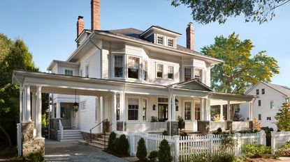 Queen anne home with white exterior, porch and columns and picket fence
