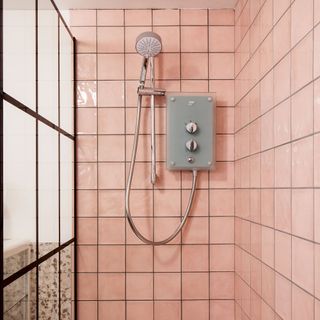 shower room with pink tiles and glass door