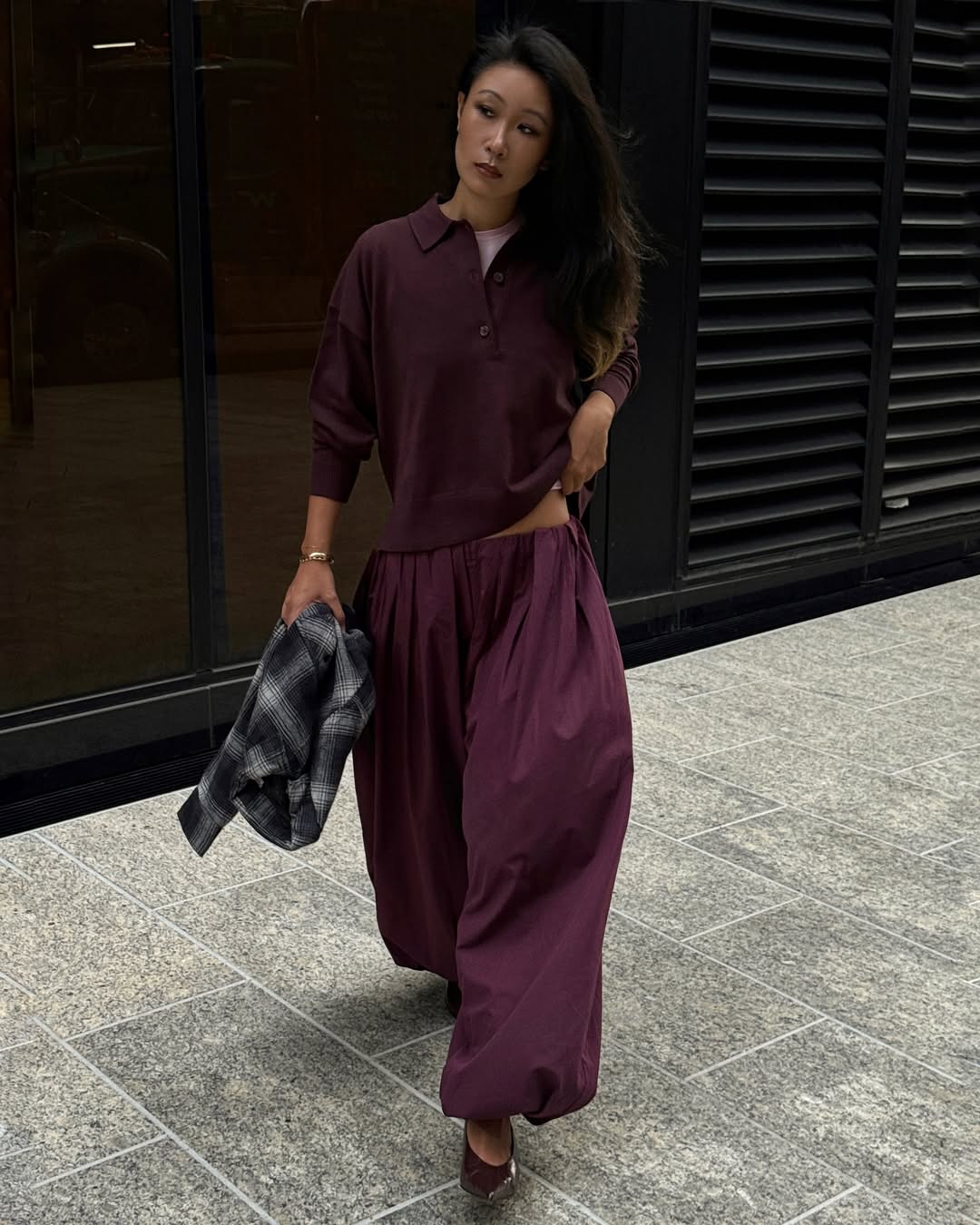Influencer Caroline Lin wearing low-rise trousers with a polo shirt.