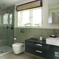 bathroom with basin and commode with glass wall