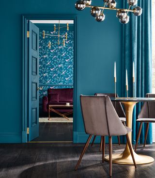 teal green colour wall and curtain with wooden flooring and dining set