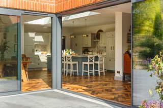 A glazed door with view into the kitchen with wood flooring