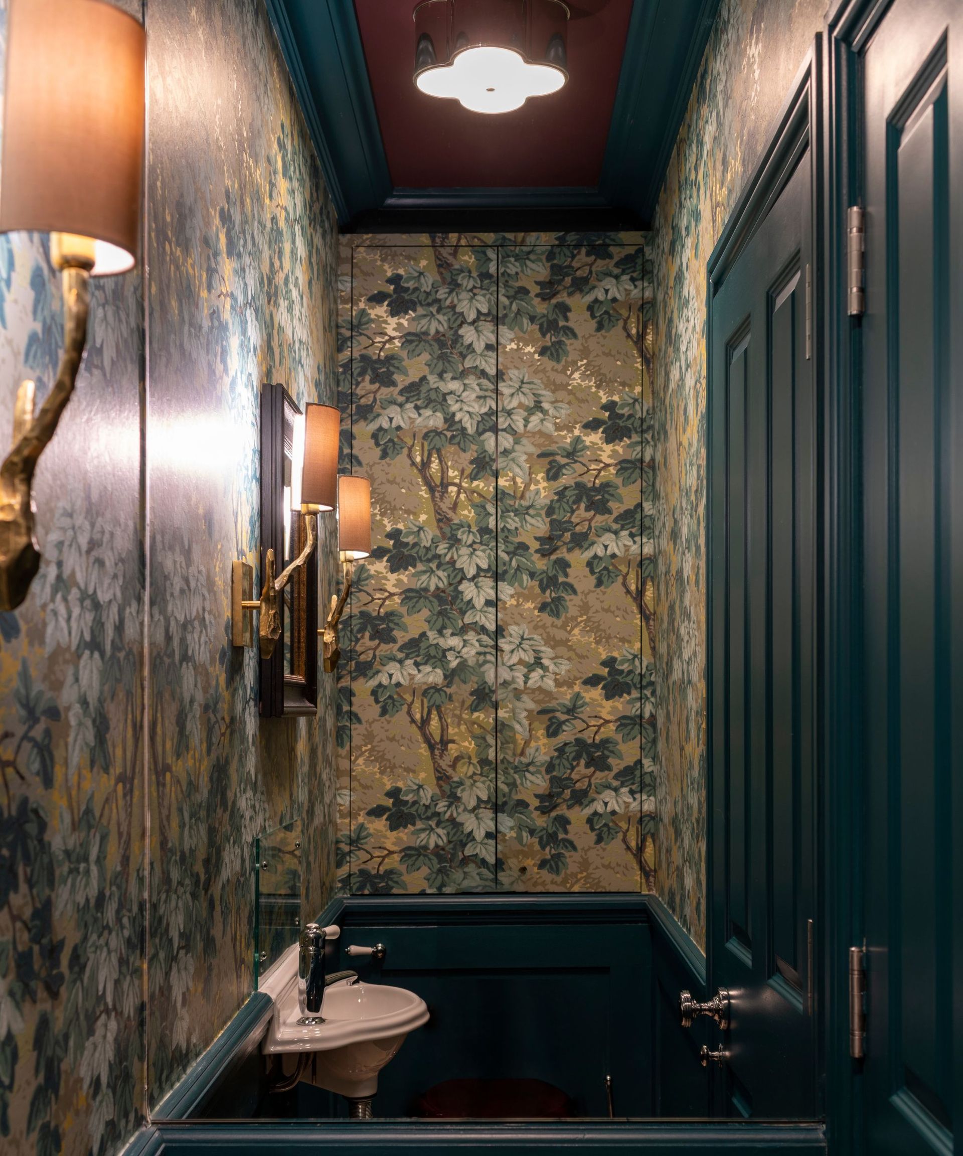 Windowless powder room with dark wallpaper