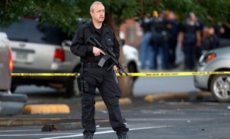 A SWAT team officer stands outside the Aurora, Colo., apartment building where James Holmes, the alleged gunman, was living.