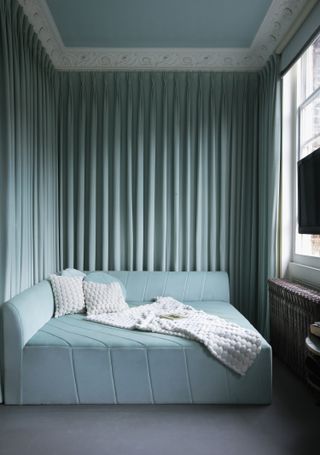 blue wrap around curtains in a small bedroom
