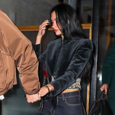 Dua Lipa wearing a cropped black velvet jacket with dark denim jeans and zebra-print pumps in NYC