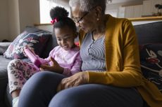 Granddaughter showing digital tablet to grandmother