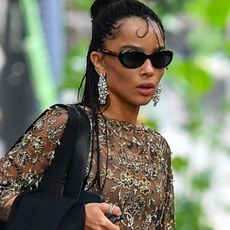 07/03/2026 EXCLUSIVE: Zoe Kravitz is spotted headed to Taylor Swift's wedding in New York City. The American actress carried a black handbag and wore a gold dress and matching heels.