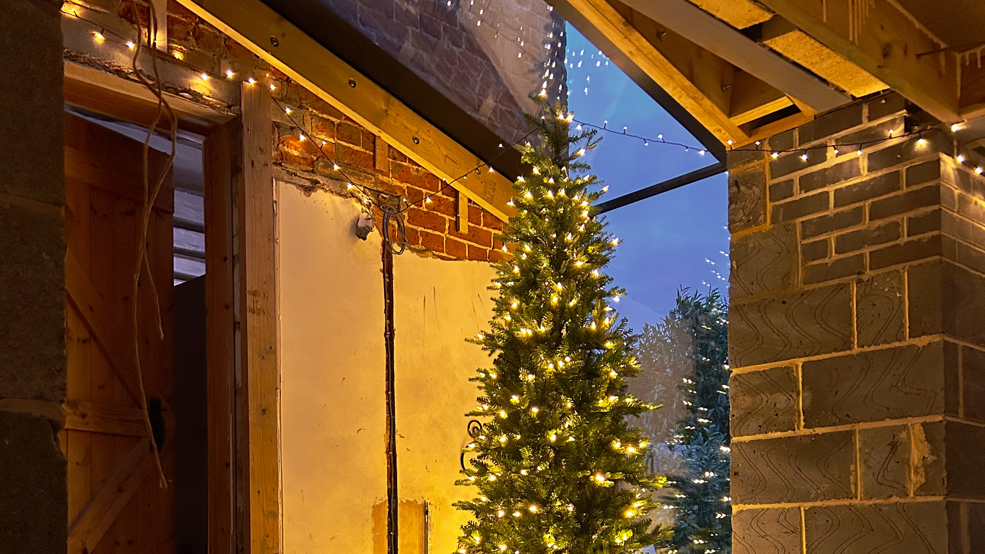 lit christmas tree in a half-renovated extension