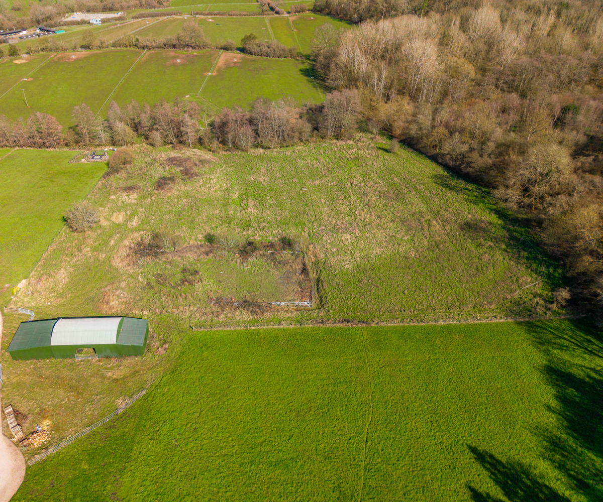 Dutch barn surrounded by fields and woodland