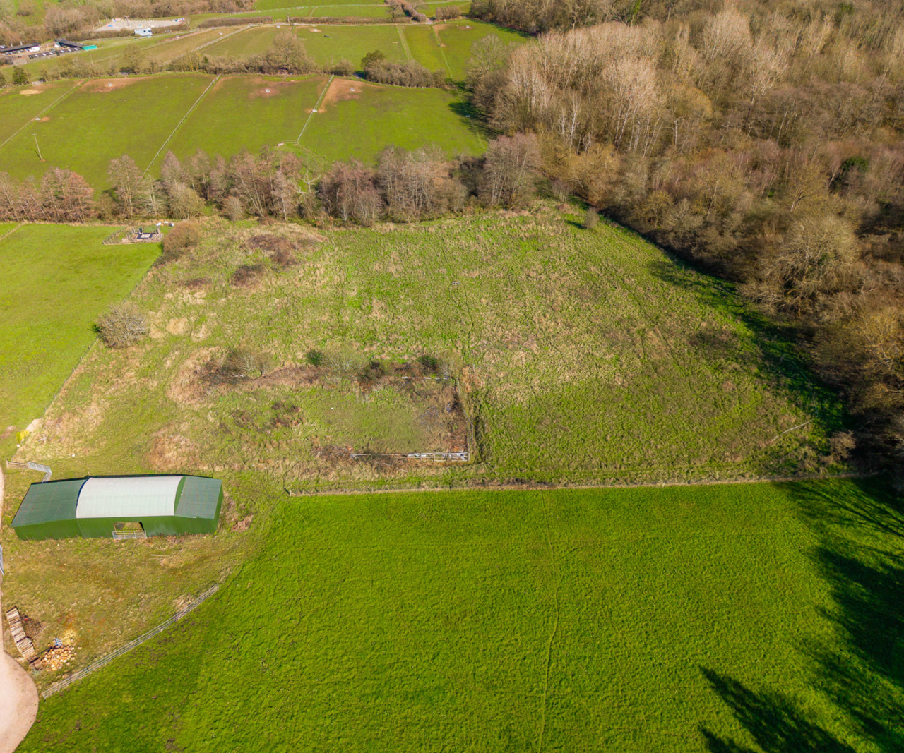 Dutch barn surrounded by fields and woodland