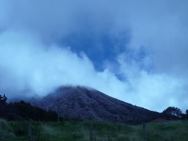 The volcano was dusted with ashes that'd fallen on its tree-covered slopes