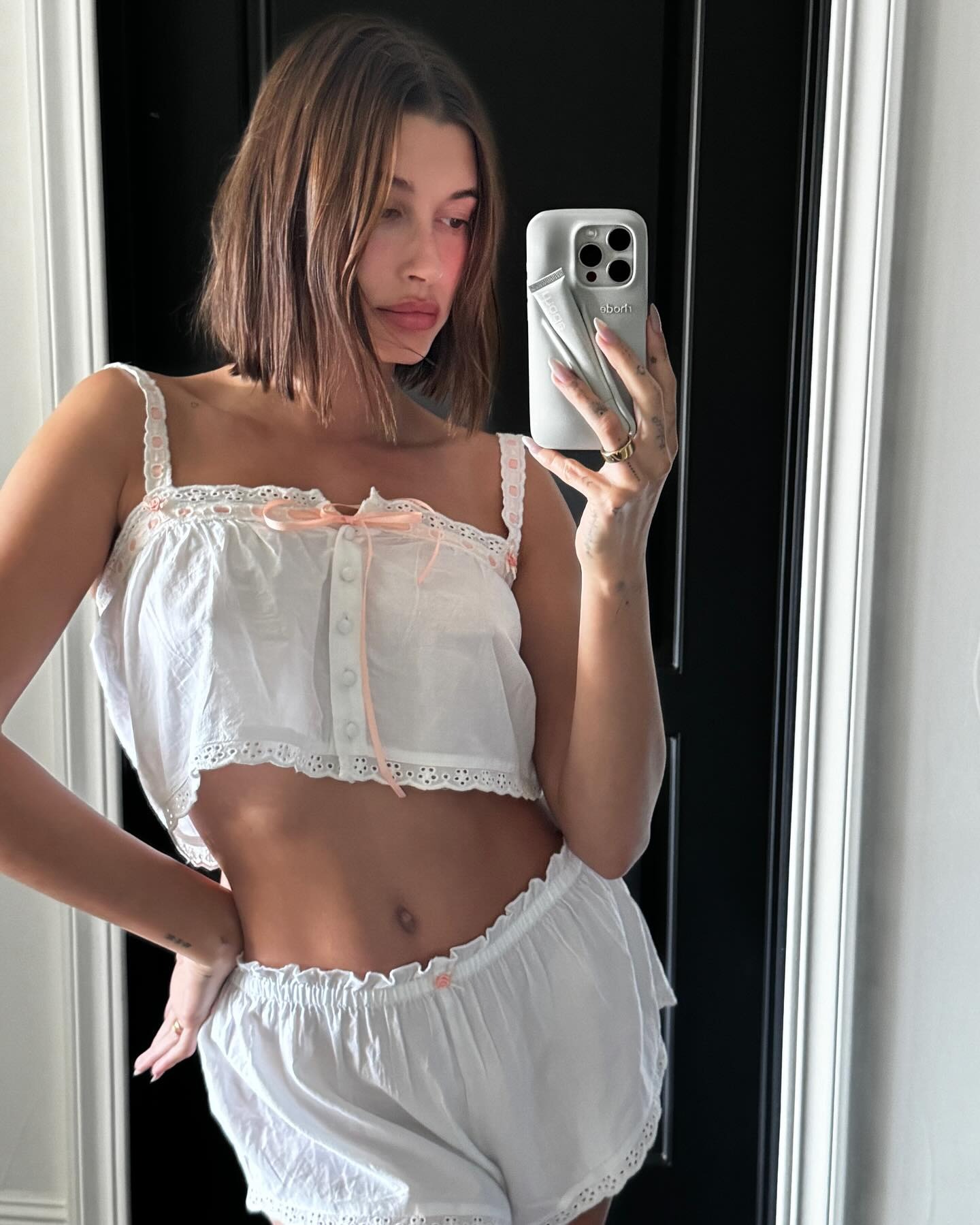 Hailey Bieber taking a mirror selfie with a bob hairstyle