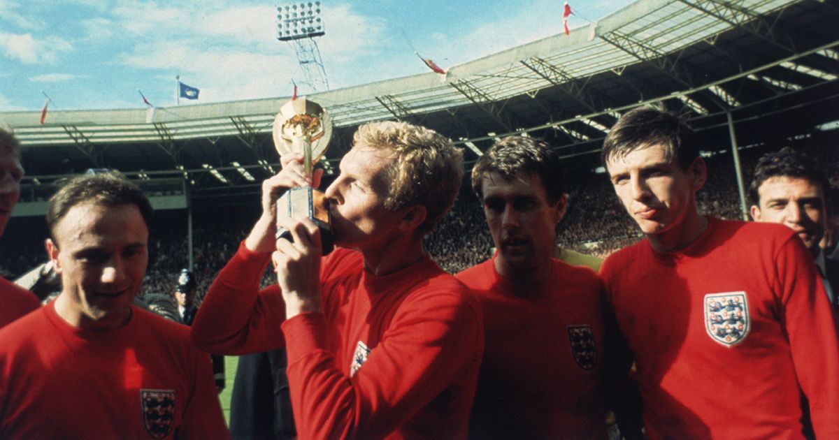 England captain Bobby Moore kissing the Jules Rimet trophy as the team celebrate winning the 1966 World Cup final against Germany at Wembley Stadium. His team mates are, left to right, George Cohen, Geoff Hurst and Martin Peters, 30th July 1966.