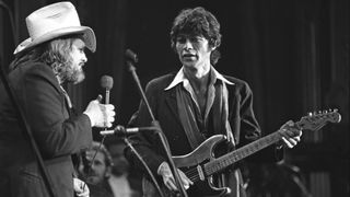 Ronnie Hawkins and Robbie Robertson (playing a Fender Stratocaster electric guitar) perform on stage at The Band's 'The Last Waltz' concert at Winterland Ballroom on November 25, 1976 in San Francisco, California.