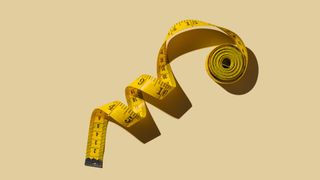 Measuring tape on beige background