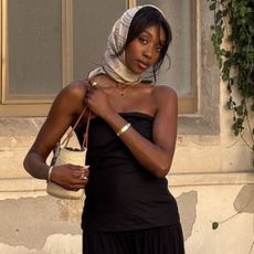 @emmanuellek_ wears a monochrome silk scarf with a black bandeau maxi dress, basket bag and mules 