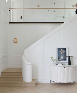 stairway with cream walls and curved rail