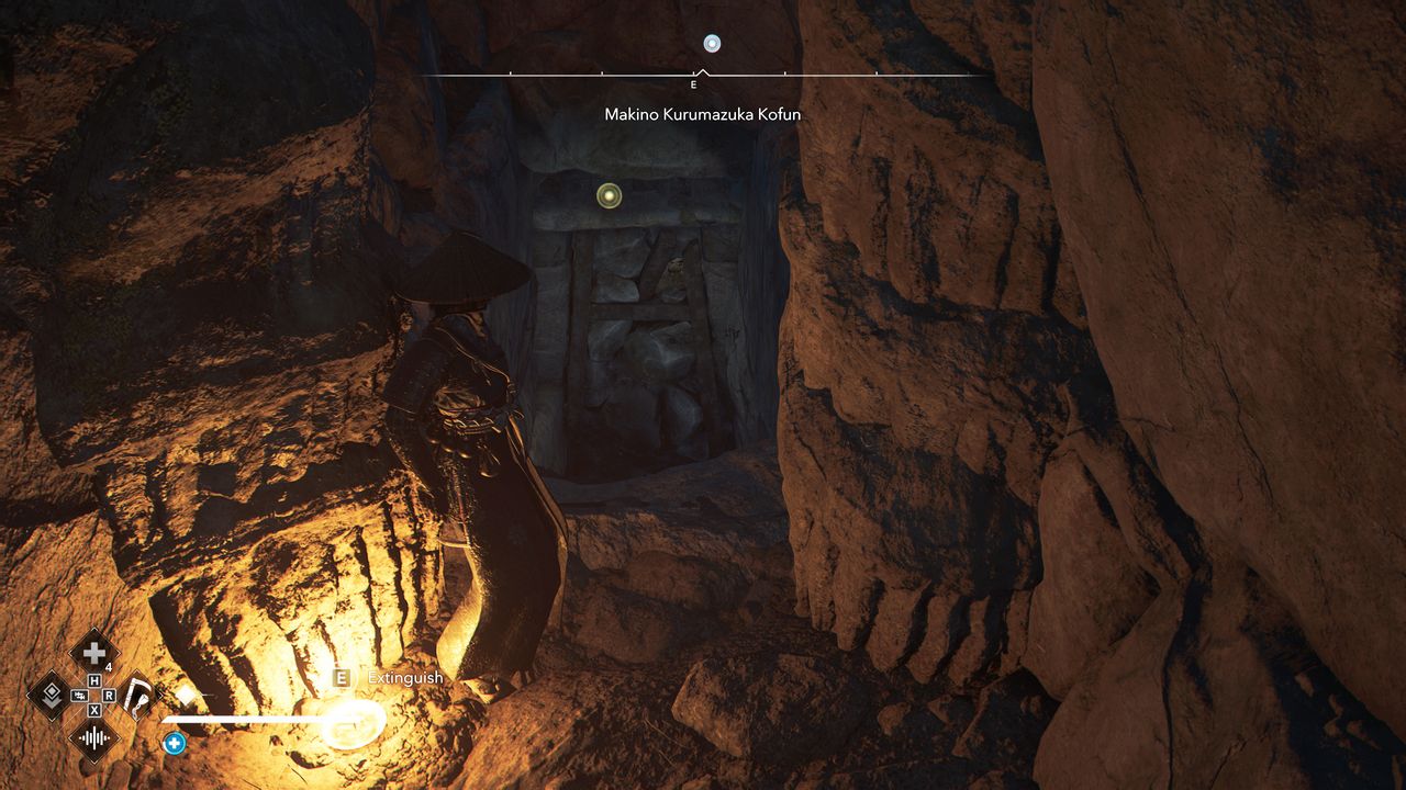 Assassin's Creed Shadows Makino Kurumazuka Kofun - Naoe tucked into the cave wall, revealing a blocked doorway at the bottom of the stairs.