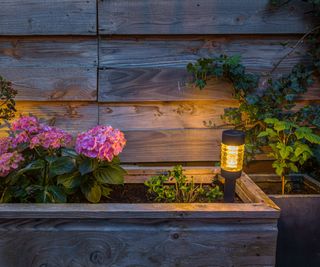 Post light lighting up a fence