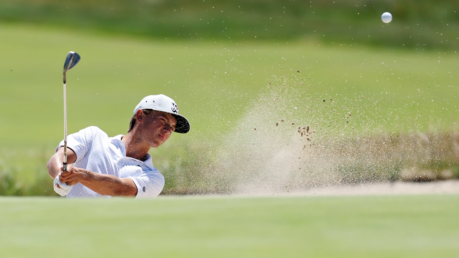 Miles Russell hits a wedge shot out of the bunker