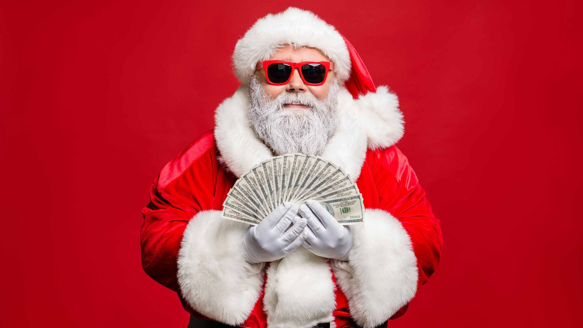 Santa Claus holding money that is fanned out